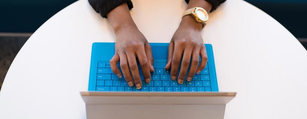 Woman typing on blue keyboard